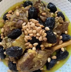 A traditional Moroccan lamb tagine served in a clay pot with prunes, almonds, and aromatic spices.