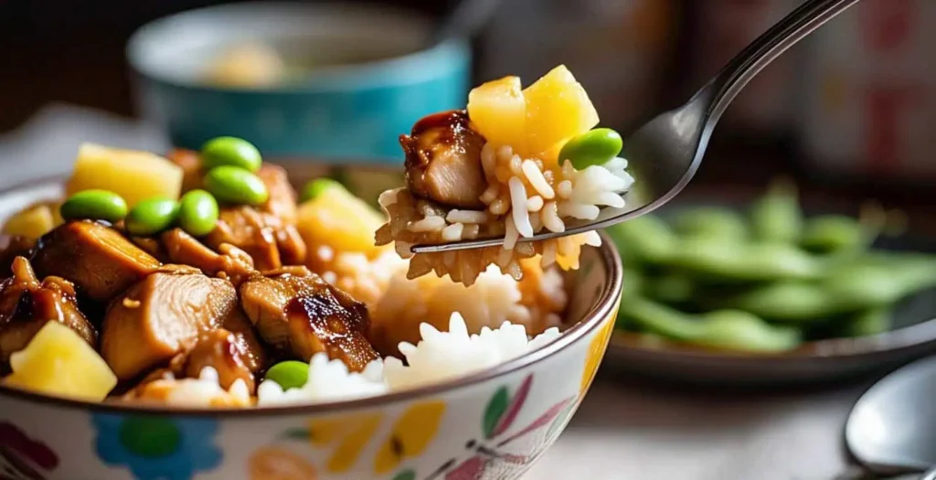 Fire Up the Grill: Best Teriyaki Chicken and Rice Bowl That’ll Make You Skip Takeout 4 Forkful of teriyaki chicken, rice, pineapple, and edamame with bowl in background